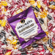 Jakemans Blackcurrant Menthol Lozenges bag packaging blackcurrant flavour 12 x 73g serving suggestion image