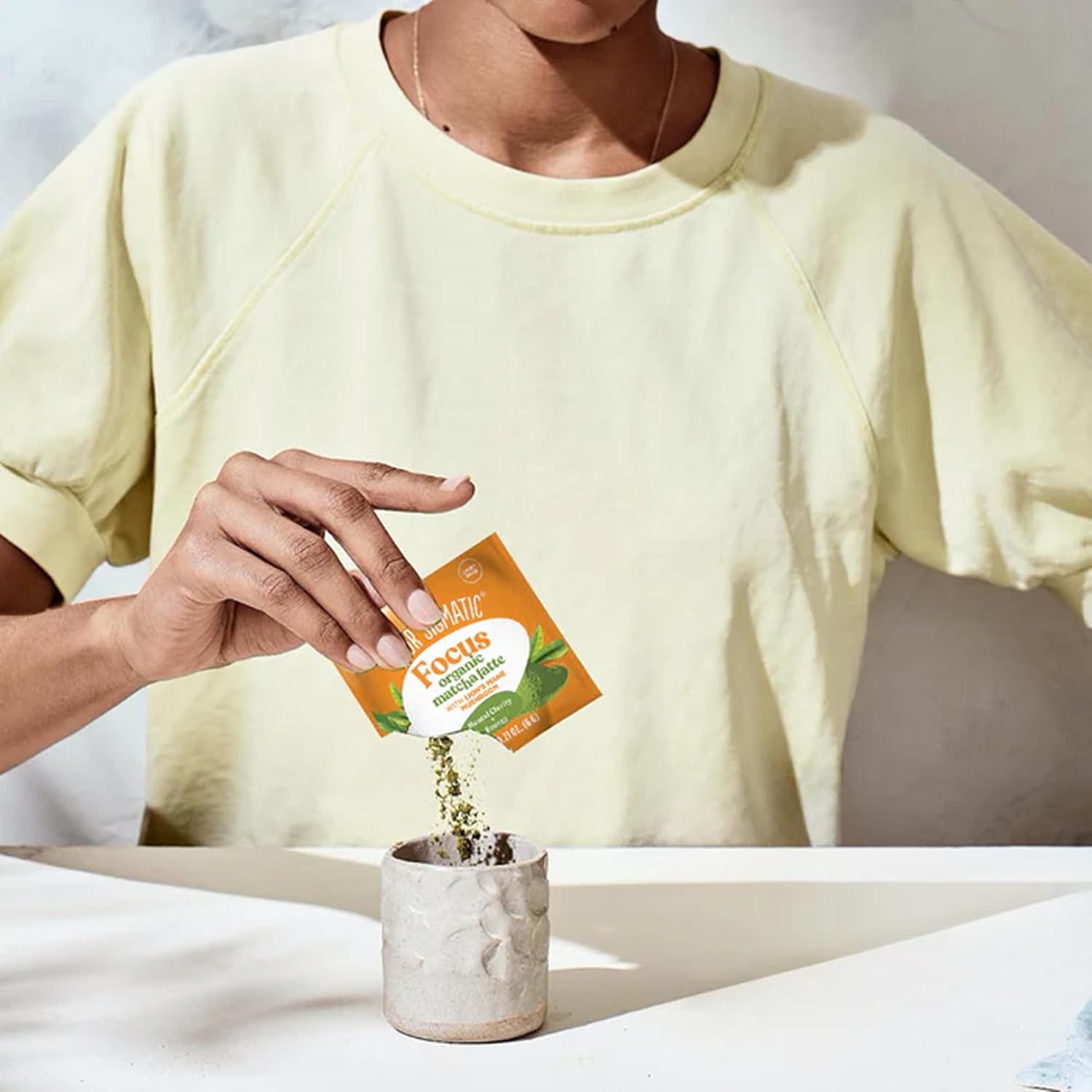 How to Use: Four Sigmatic Matcha Latte packet being mixed in a mug.