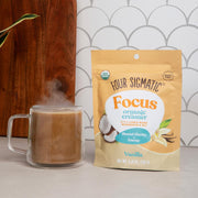 Four Sigmatic creamer to a steaming mug.