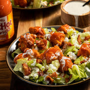 Lifestyle/use image: Franks RedHot buffalo sauce used on wings and food bottle 680ml